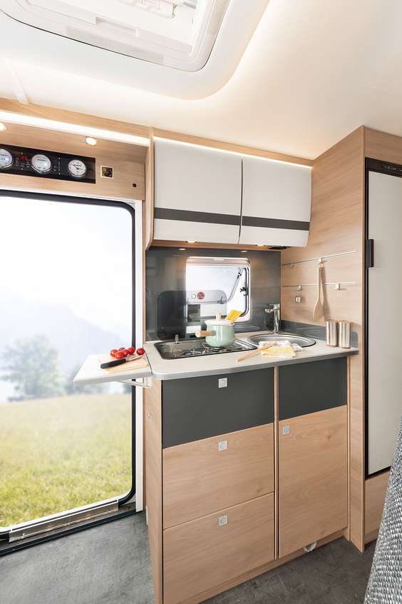 Compacta e mesmo assim tudo no interior: cozinha totalmente equipada com abastecimento de água quente, fogão a gás, gavetas grandes e frigorífico. • T/I 6
