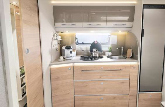 Amplia cocina con práctico compartimento vertical, espacio para la cafetera, cocina de 3 fuegos con encendido eléctrico y pared trasera iluminada • 520 ELT | Ruby