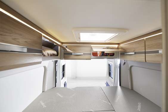 Os armários suspensos de série acima da porta traseira fornecem espaço de arrumação adicional e têm iluminação indireta.