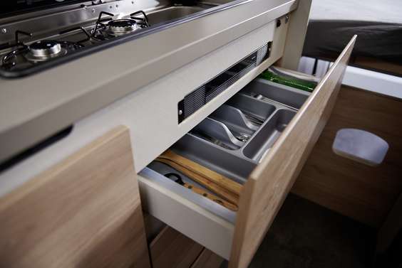 Gavetas amplas e espaçosas sem puxadores com fecho central manual guardam em segurança todos os utensílios de cozinha.