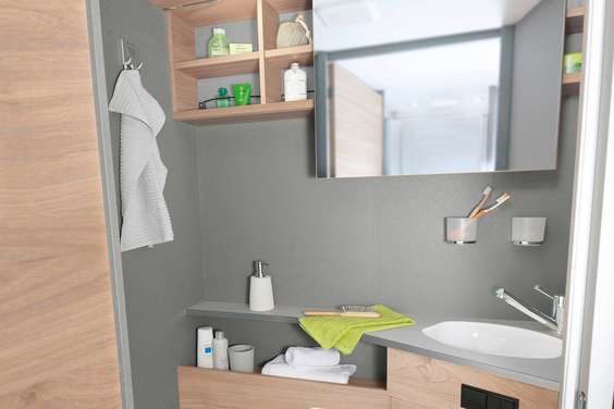 Casa de banho clara e luminosa, com um prático espelho deslocá- vel para o lado e muitas opções de armazenamento e arrumação