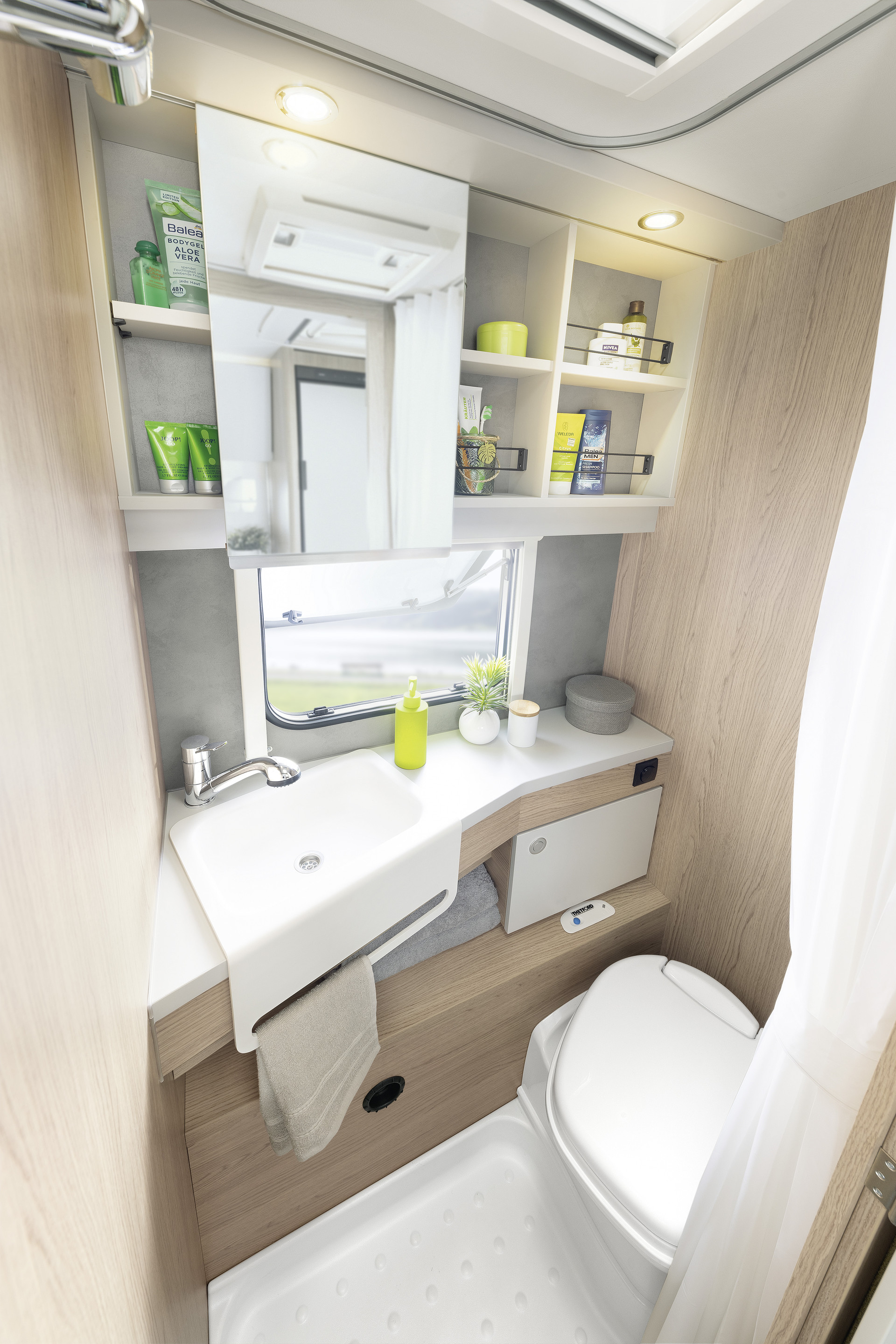 Baño compacto en colores claros y bonitos y prácticos detalles como el toallero integrado y el práctico armario con espejo • 510 ER | Skagen