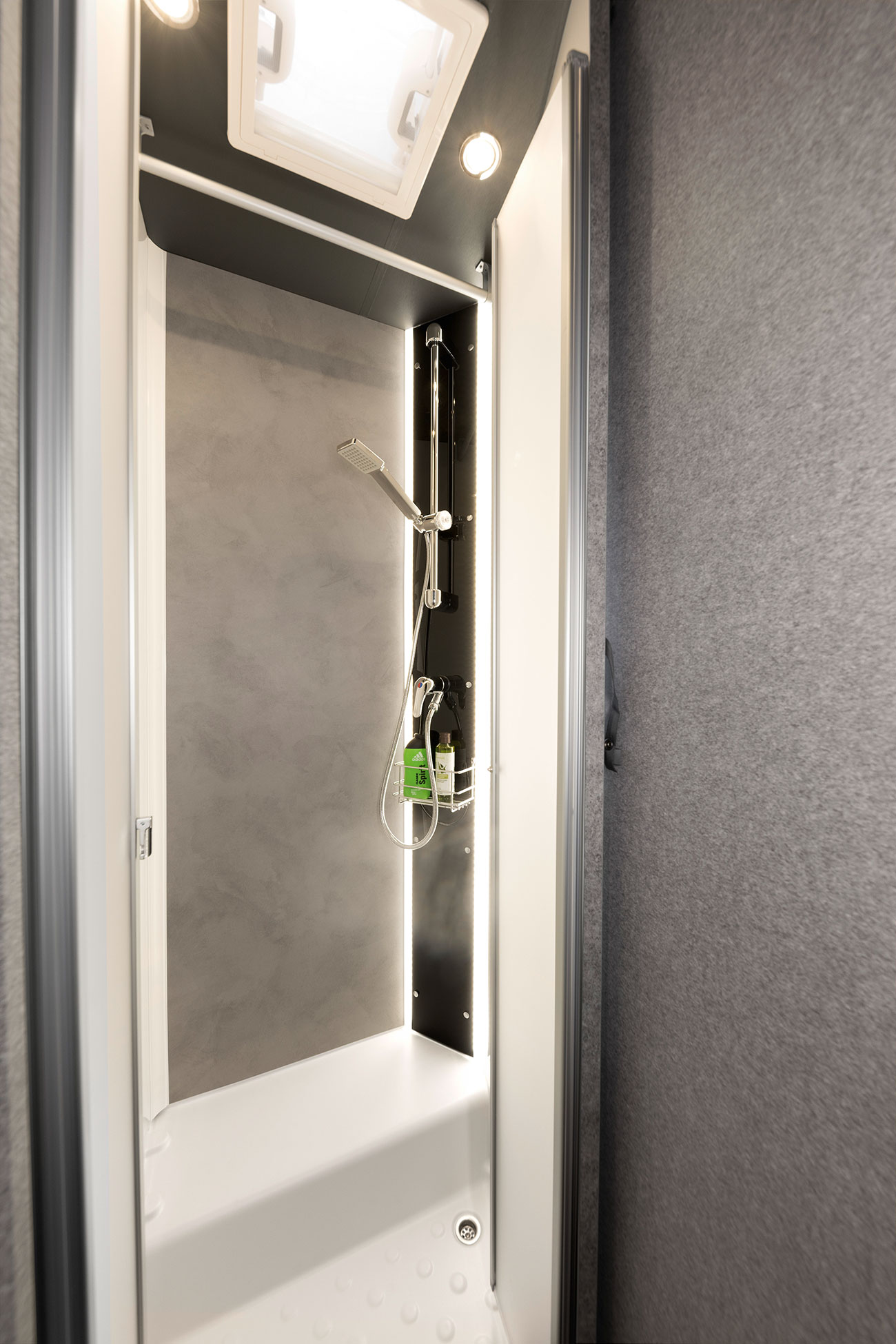 O duche é particularmente espaçoso e tem um design elegante. A consola de duche, com luz indireta, faz parte da iluminação ambiente opcional Light Moments.